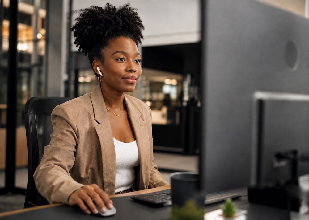 A person at an office desk working at a computer.